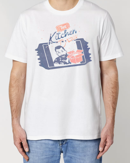 A man wearing a white short-sleeve t-shirt with a colourful graphic print on the front that reads 'The Kitchen Draw' and features a stylised portrait, set against a plain light grey background.
